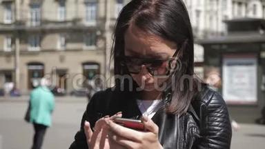 女人在城市街道上的智能手机上搜索信息。 技术和生活方式理念..